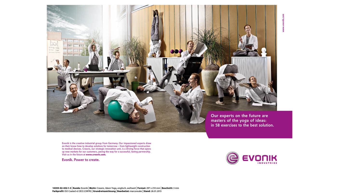 Anuncio de Evonik «yoga de ideas»: expertos con bata de laboratorio haciendo yoga en una oficina